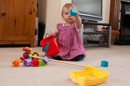child playing with shape sorter bucket