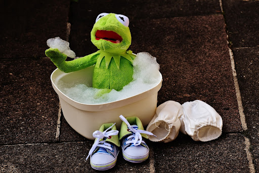 stuffed animal kermit the frog in wash tub with suds