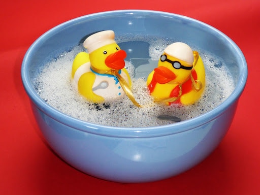 wash bowl with 2 rubber ducks and suds