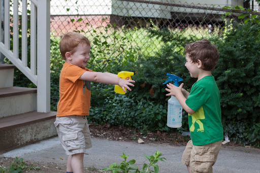 two boys playing spraying each other with water